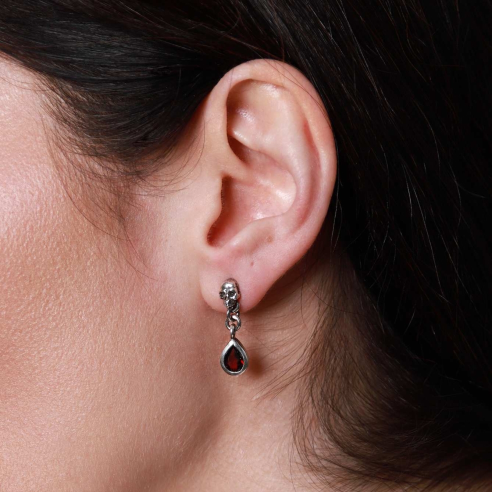 Sterling silver skull stud drop earrings with garnet pear shaped stone setting.