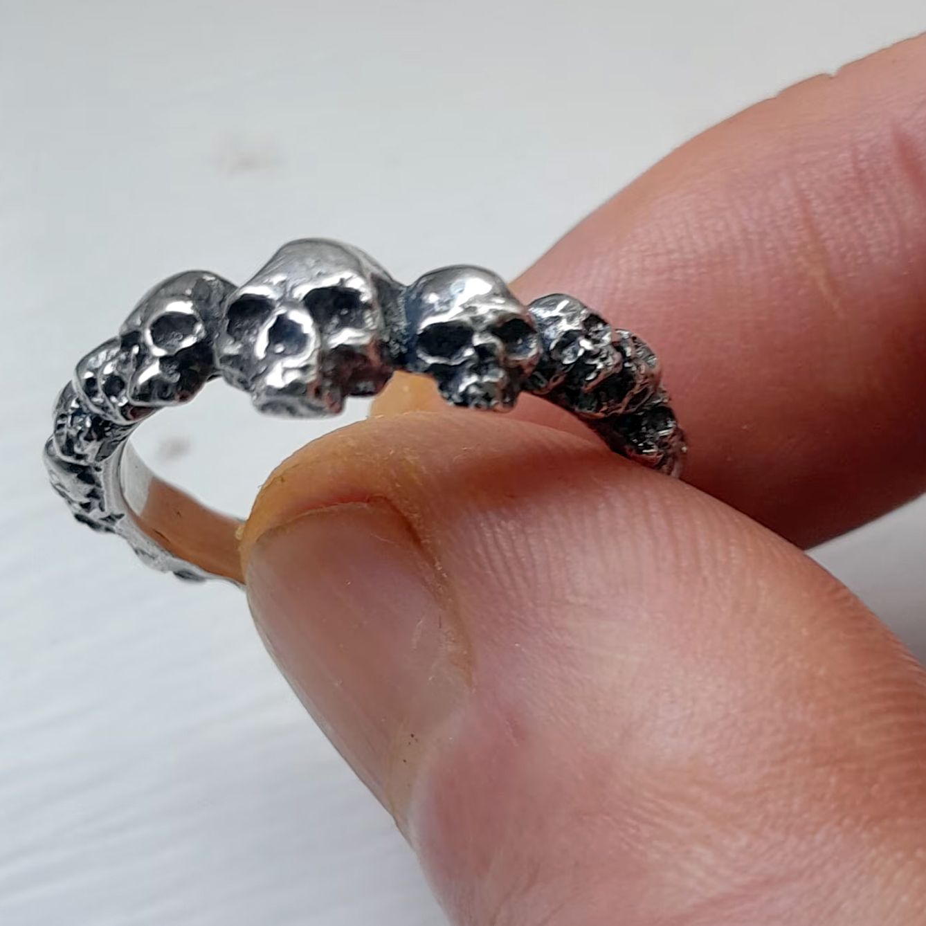 Ring of skulls between thumb and forefinger