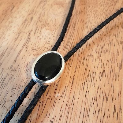 Bolo tie with black onyx stone and sterling silver snake heads.