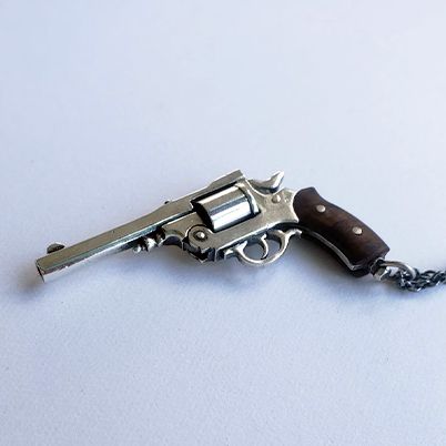Sterling silver revolver necklace.  Revolver has moving cylinder and hammer with wood handle.